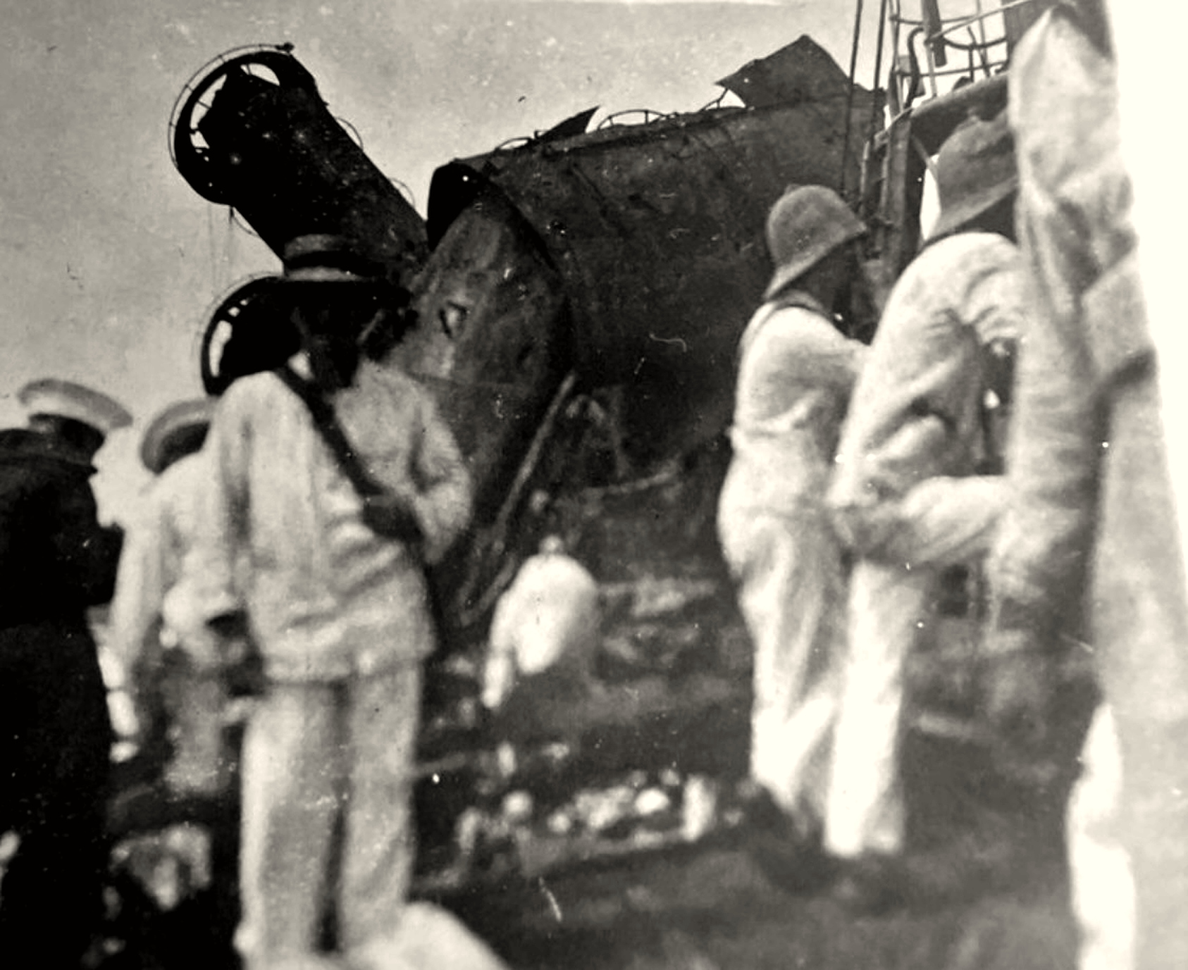 Men standing on SMS Emden beside a badly damaged funnel and gun