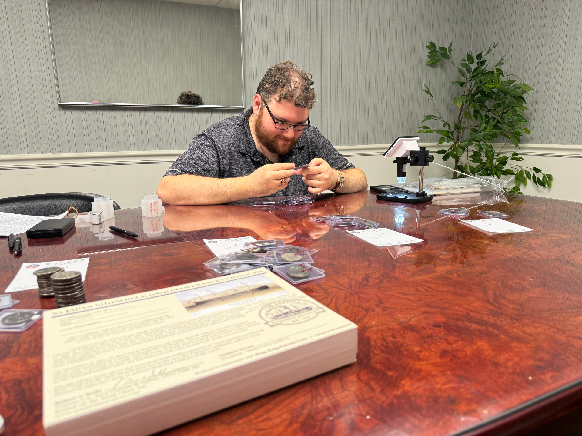 Matt cataloging recovered SS Japan Trade Dollars at the table