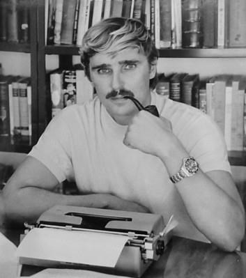 Black and white portrait of Robert F. Marx seated at a typewriter with a pipe