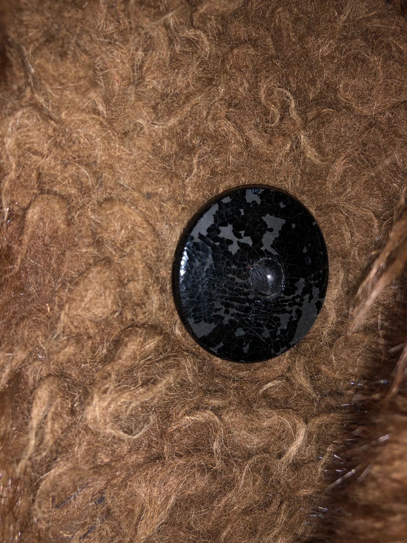 Macro of a single domed black button with crackled finish