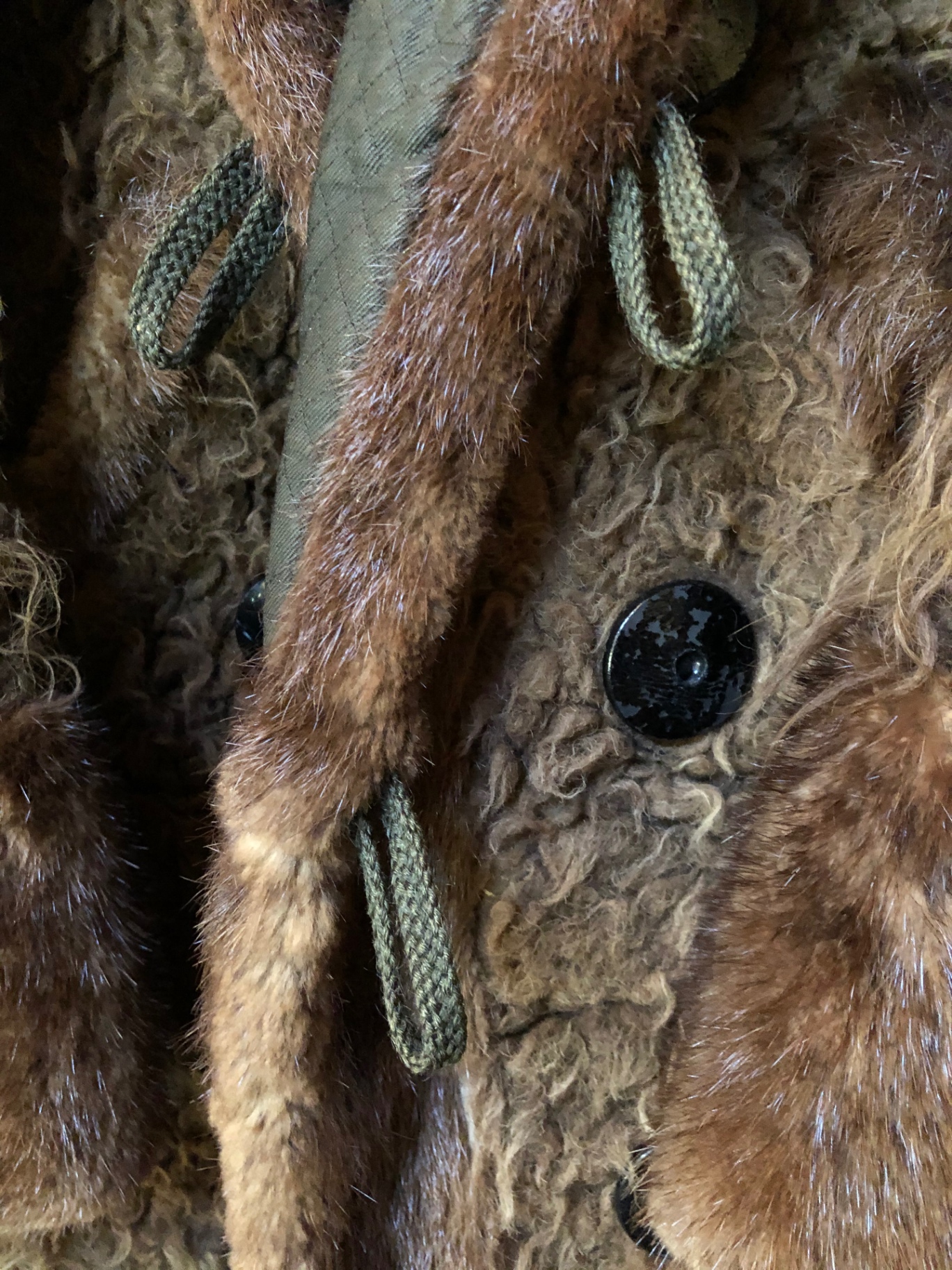 Close-up of the lapel showing braided green wool frog loops and a domed black button